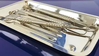 Błyszcząca metalowa taca zawierająca kilka narzędzi dentystycznych ze stali nierdzewnej, często używanych do chirurgicznego usuwania ósemek, jest umieszczona na niebieskiej powierzchni. Narzędzia mają teksturowane uchwyty i zaostrzone lub haczykowate końce.